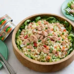 A large bowl of the best macaroni tuna salad with fresh vegetables and creamy dressing.