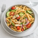 Greek Chicken Pasta Salad in a wooden bowl