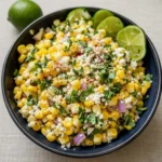 Mexican Street Corn Salad in a bowl with lime and cilantro