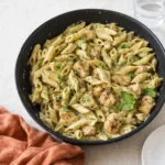 A delicious plate of Creamy Chicken Chicken Pesto Pasta with fresh basil and parmesan.